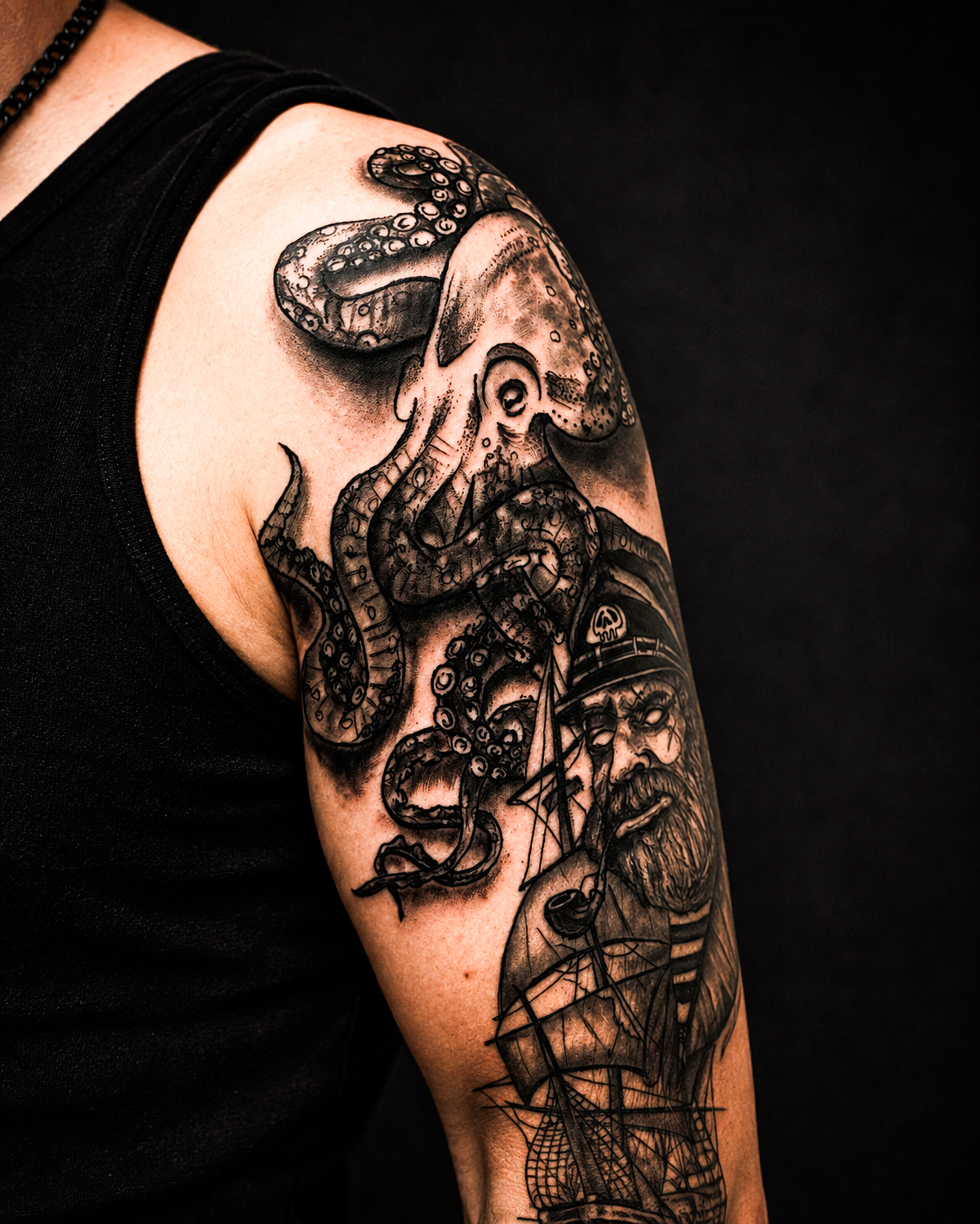 Oberarm-Tattoo mit Krake und altem Seemann samt Segelschiff, illustrativer Dark-Art-Stil
